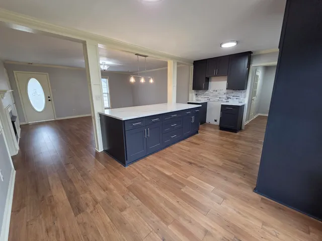 a large room with wooden floor and a sink