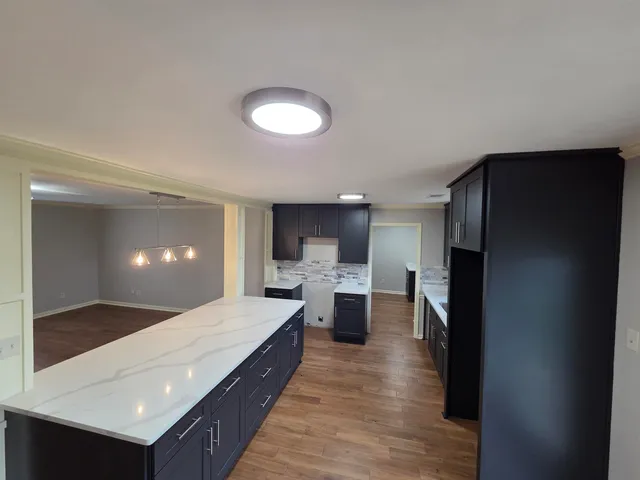 a large white kitchen with a large window and stainless steel appliances