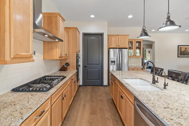 a kitchen with stainless steel appliances granite countertop a sink stove and refrigerator