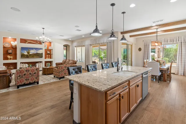 a kitchen with stainless steel appliances granite countertop a kitchen island a stove and a sink
