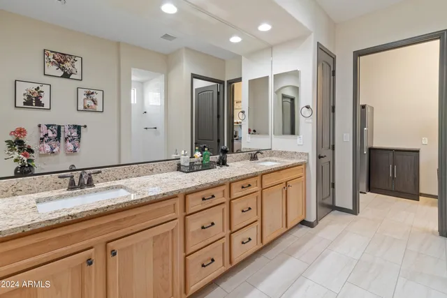 a spacious bathroom with double sink and a mirror