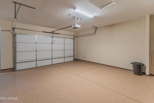 a view of empty room with refrigerator and ceiling fan