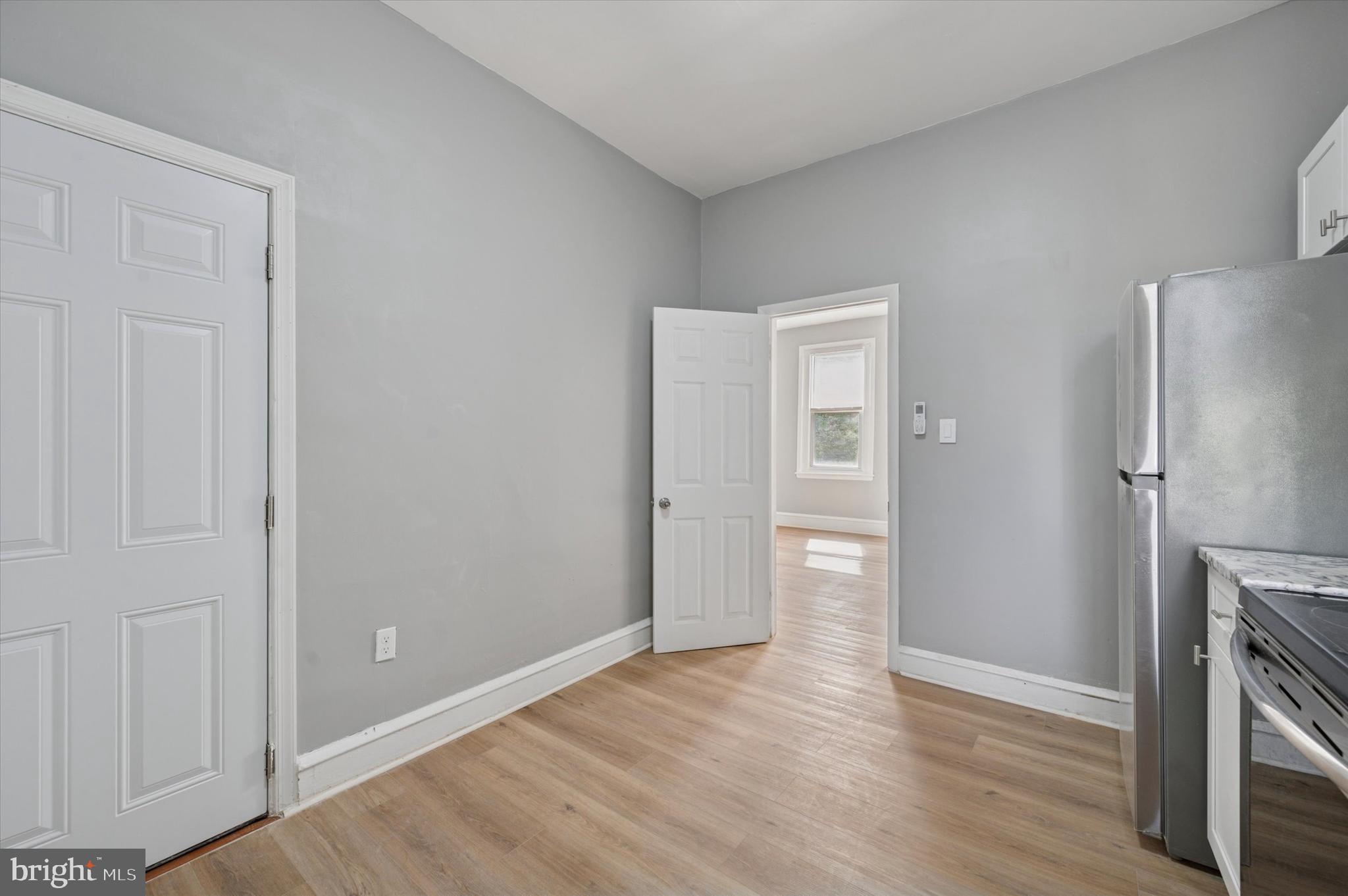 249 South 44th Street, Unit 4 Philadelphia, PA 19104 - Photo 11 of 25 a view of an empty room with wooden floor and a kitchen
