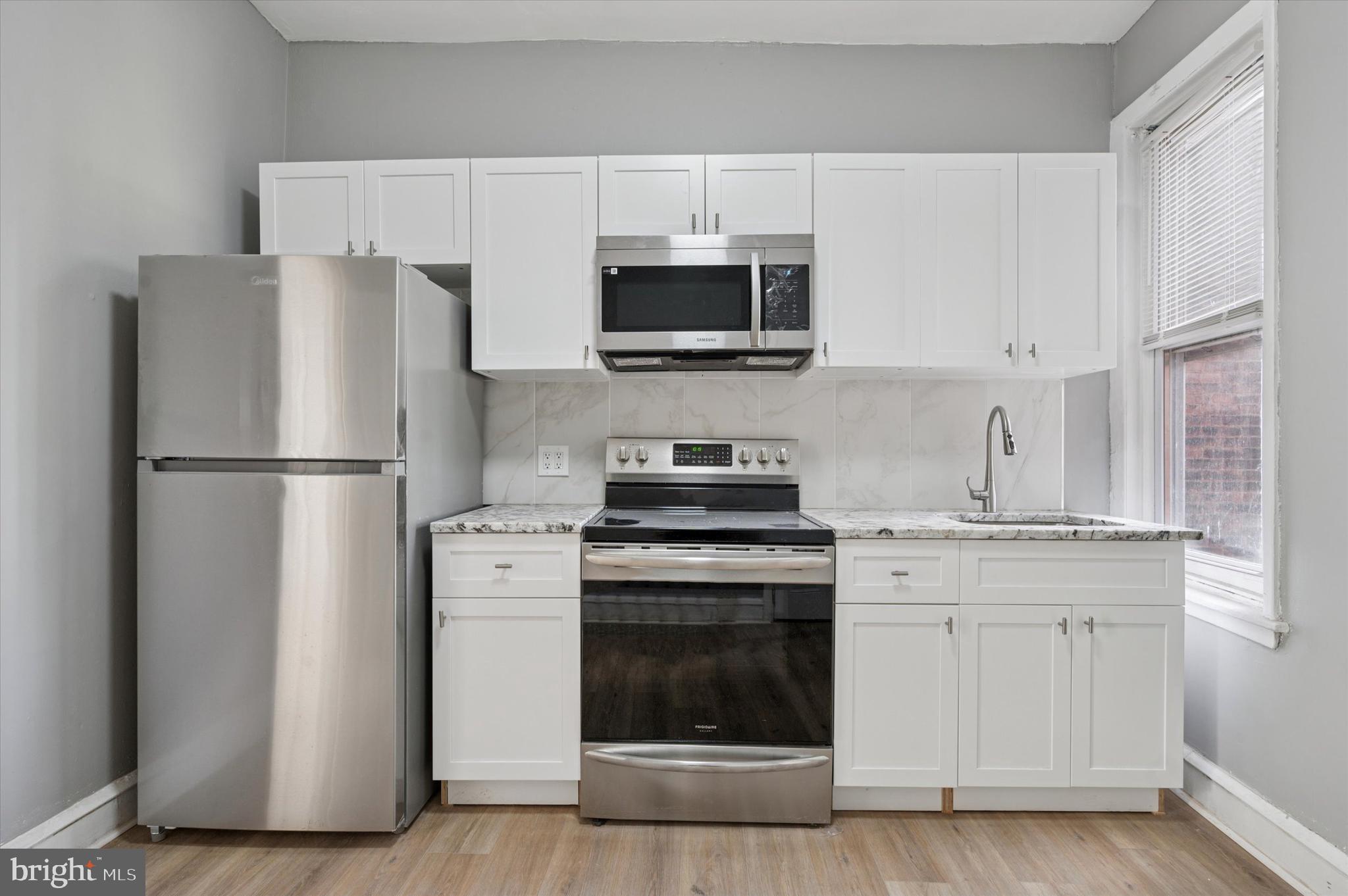 249 South 44th Street, Unit 4 Philadelphia, PA 19104 - Photo 13 of 25 a kitchen with stainless steel appliances a refrigerator stove and microwave
