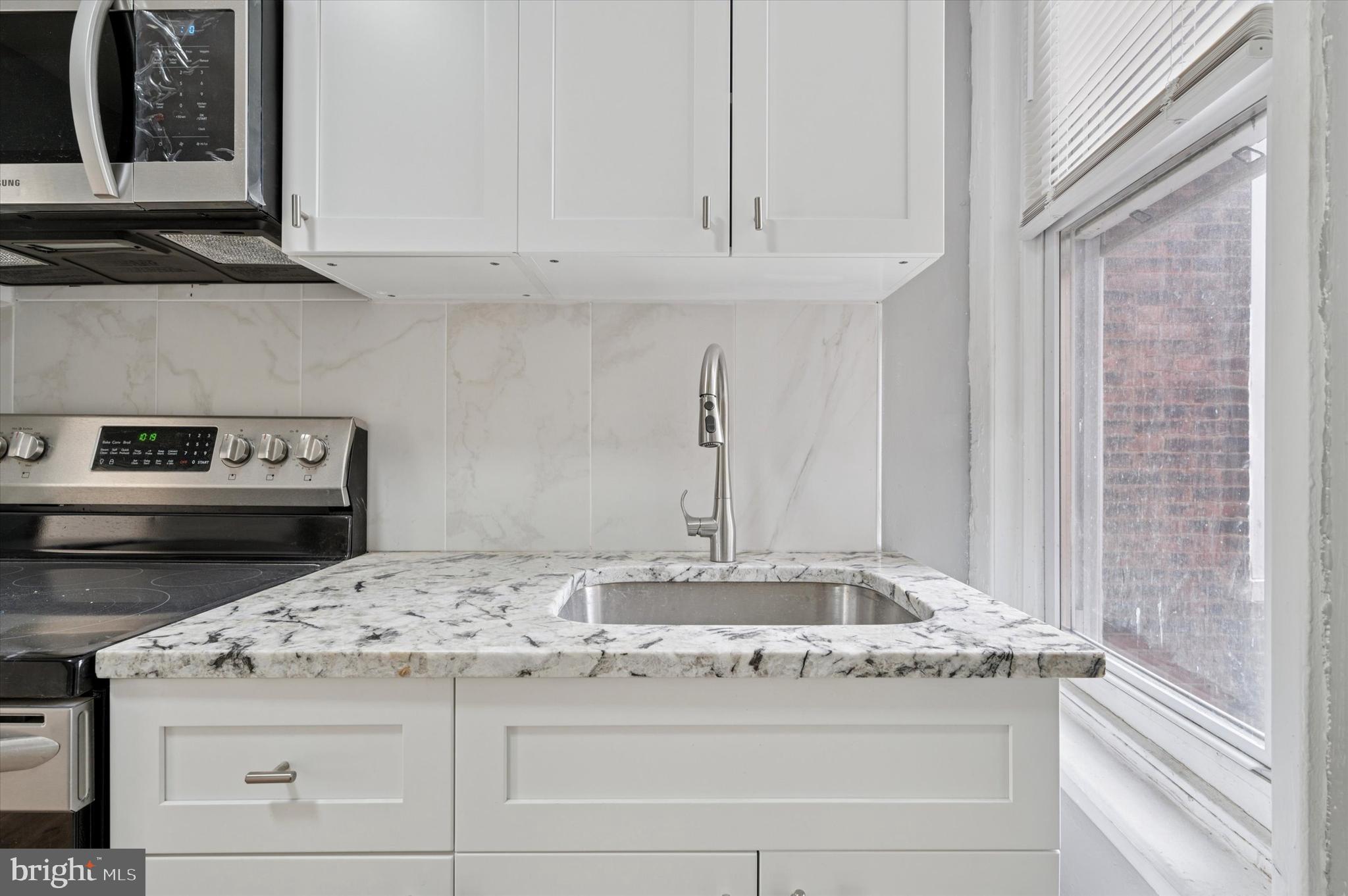 249 South 44th Street, Unit 4 Philadelphia, PA 19104 - Photo 14 of 25 a kitchen with granite countertop white cabinets and a stove