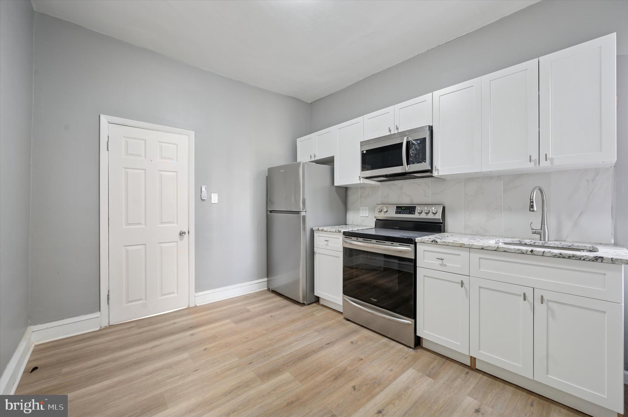 249 South 44th Street, Unit 4 Philadelphia, PA 19104 - Photo 6 of 25 a kitchen with granite countertop white cabinets and stainless steel appliances
