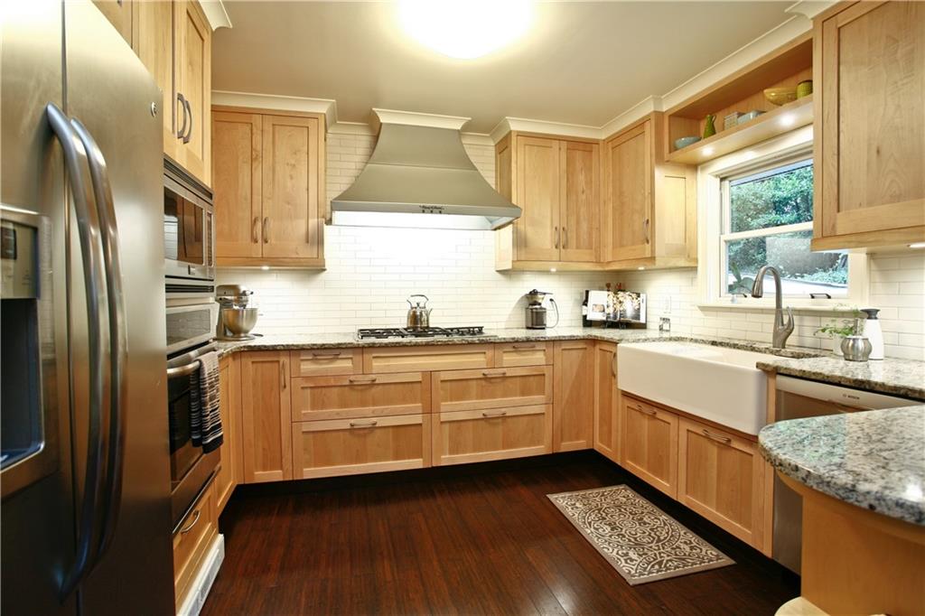 This renovated kitchen is a chef's dream complete with a 5 burner gas cook top, custom vent hood, maple cabinets and top of the line stainless steel appliances.  Meticulously designed!   Storage galore.
