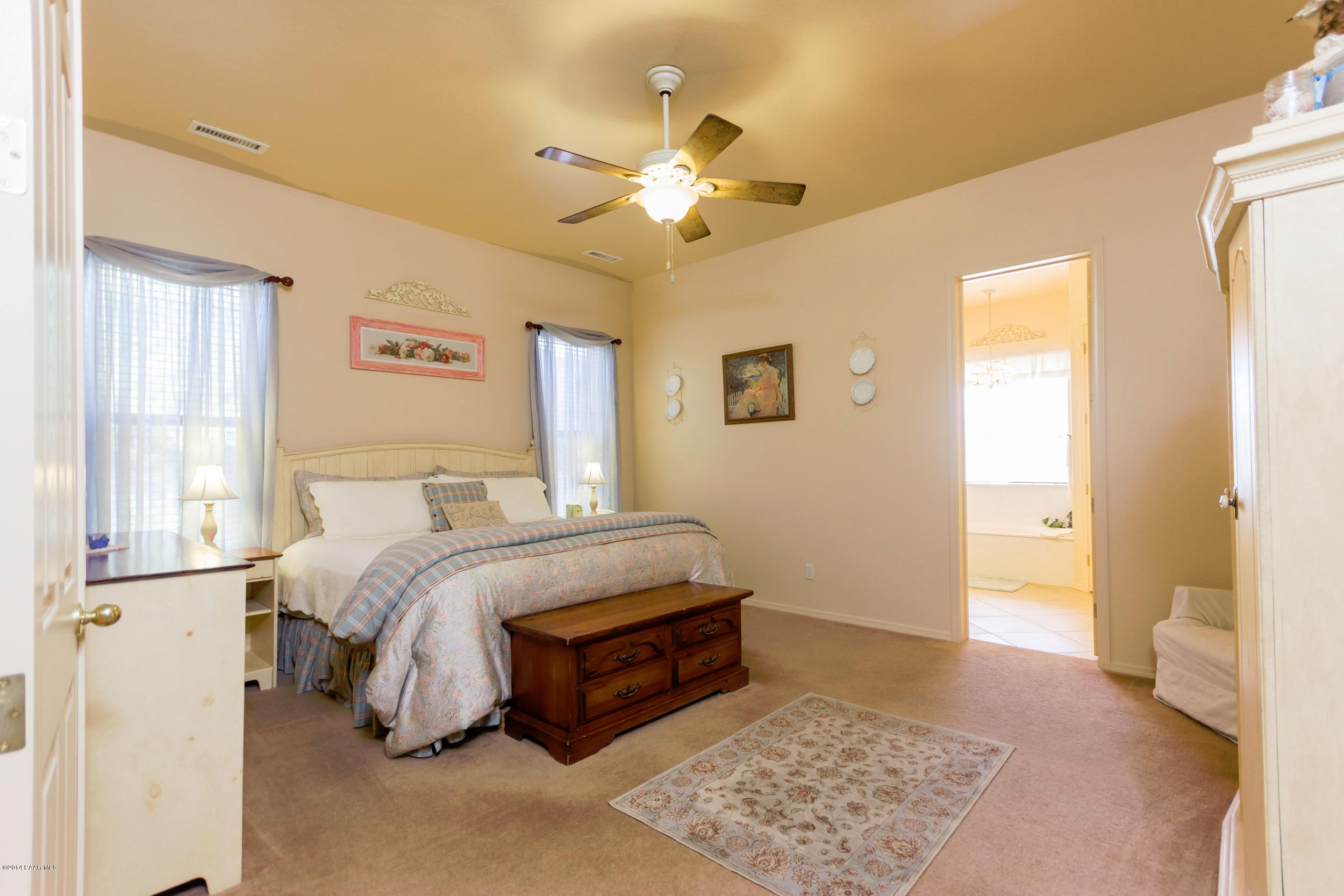 4714 Edgemont Road Prescott Valley, AZ 86314 - Photo 12 of 30 a spacious bedroom with a bed and a chandelier
