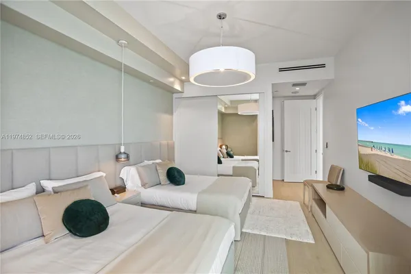 a bedroom with a bed and a chandelier