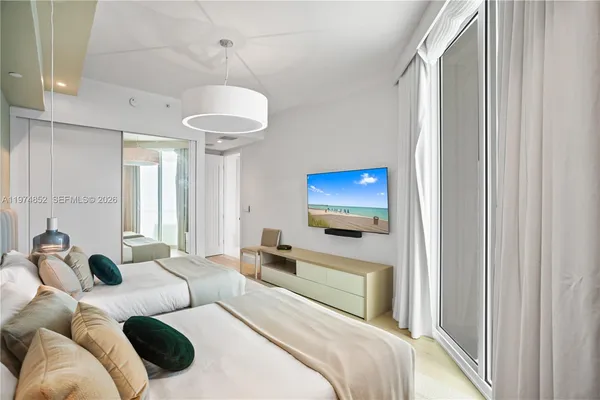 a bedroom with a bed and a flat screen tv