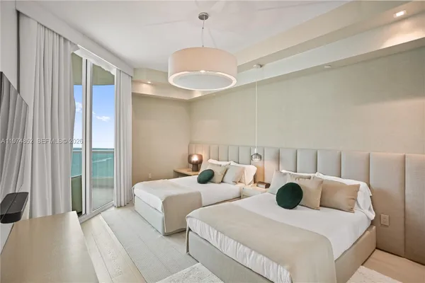 a bedroom with two beds and a chandelier