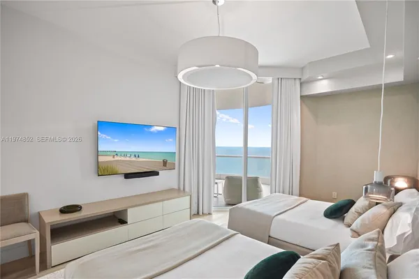 a bedroom with a bed and a chandelier