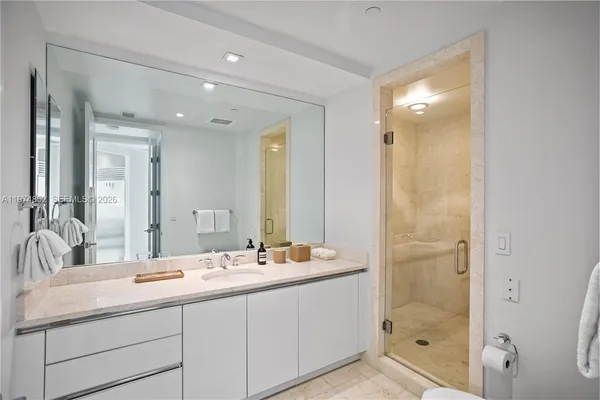 a bathroom with a double vanity sink mirror and shower