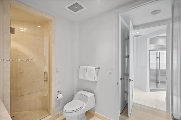 a bathroom with a granite countertop toilet a sink and shower