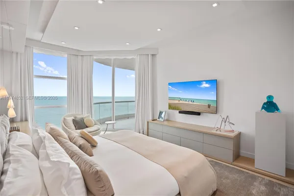 a bedroom with a bed and large windows