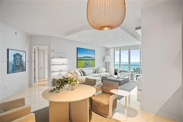 a living room with furniture a table and a large window