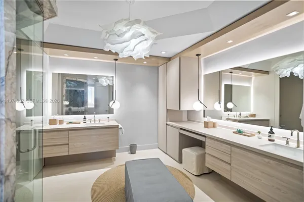 a large bathroom with a double vanity sink a large mirror and a bathtub