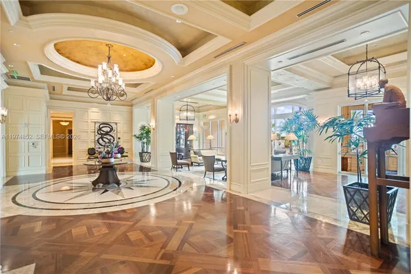 a living room with dining table and a chandelier