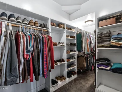 a view of walk in closet with clothes and shoes