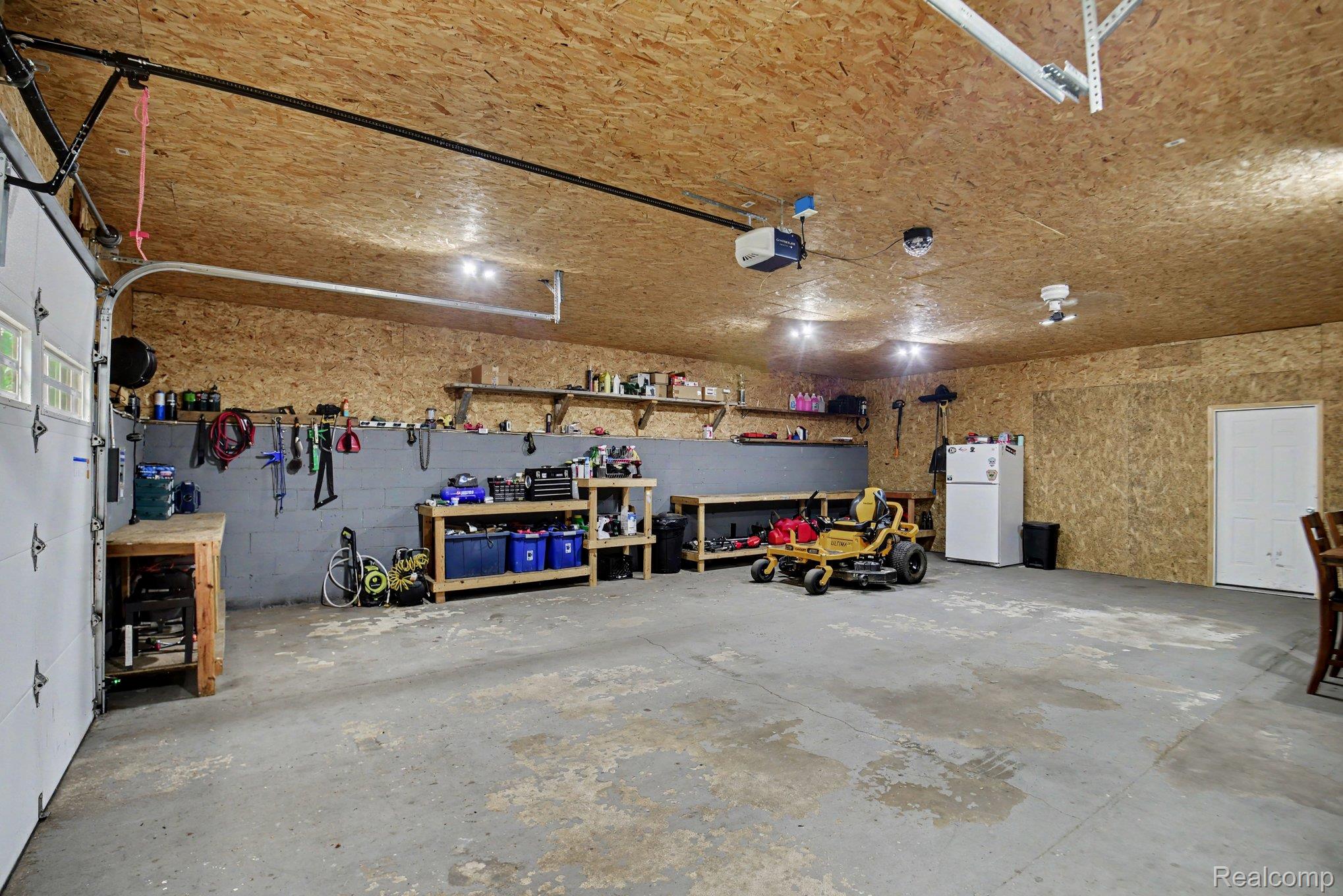 1646 Boy Scout Road Caro, MI 48723 - Photo 18 of 28 Spacious garage featuring a concrete floor, plywood walls, and overhead lighting