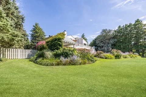 a view of a garden with a house in the background