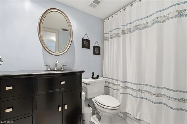 a bathroom with a sink vanity mirror and toilet