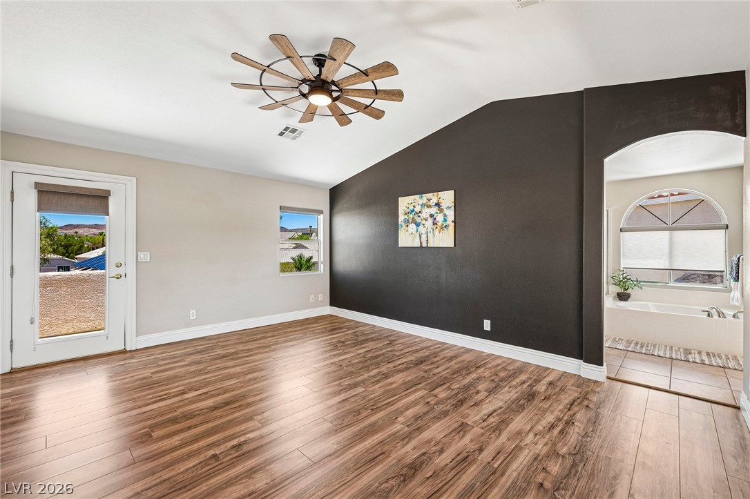 1176 Butternut Ranch Court Henderson, NV 89052 - Photo 31 of 60 Hardwood floors and vaulted ceilings elevate this spacious primary bedroom with private balcony access.