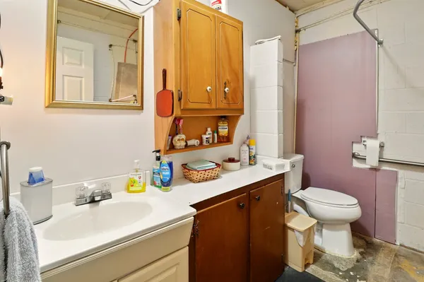 a bathroom with a sink toilet vanity and tub
