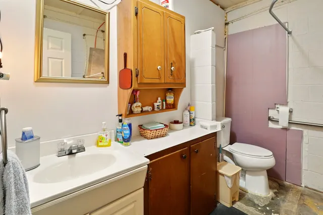 a bathroom with a sink toilet vanity and tub
