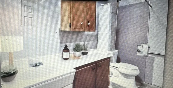a bathroom with a granite countertop sink toilet and shower