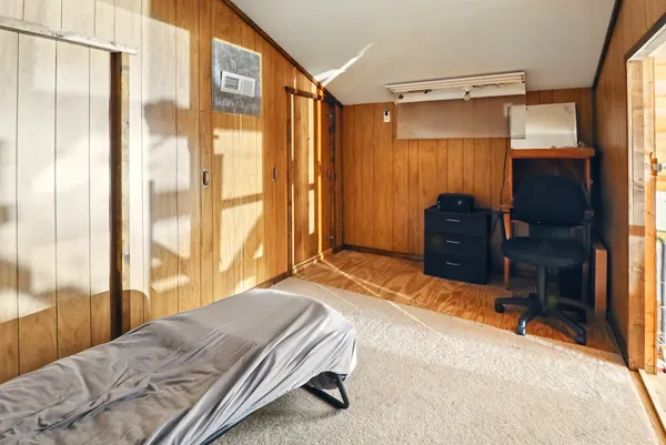 a bedroom with a bed and a dresser next to a window