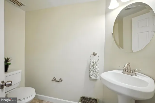 a bathroom with a sink a toilet and mirror
