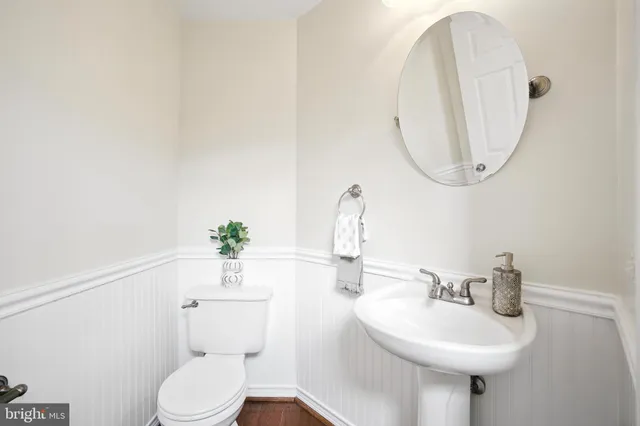 a bathroom with a sink a toilet and a mirror