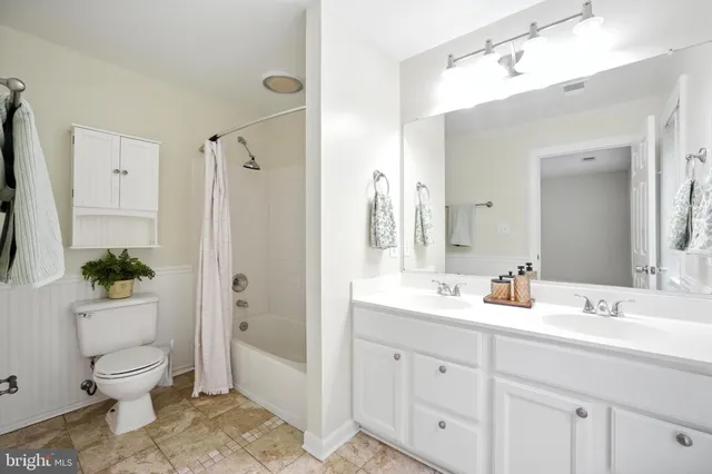 a bathroom with a double vanity sink toilet and shower