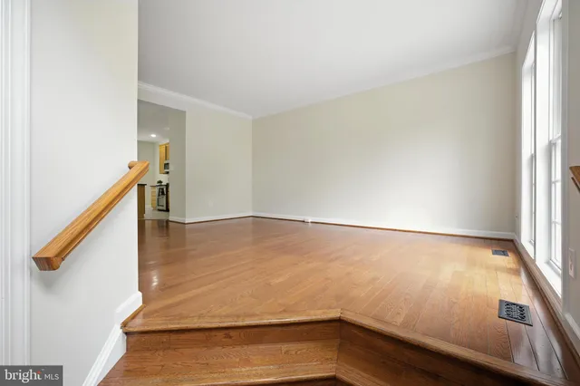 a view of an empty room with wooden floor