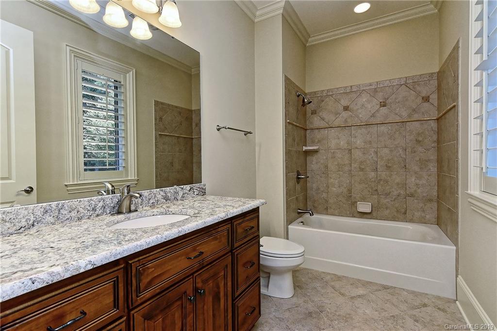 17415 Cabarrus Road Midland, NC 28107 - Photo 36 of 41 a bathroom with a granite countertop sink a toilet and bathtub