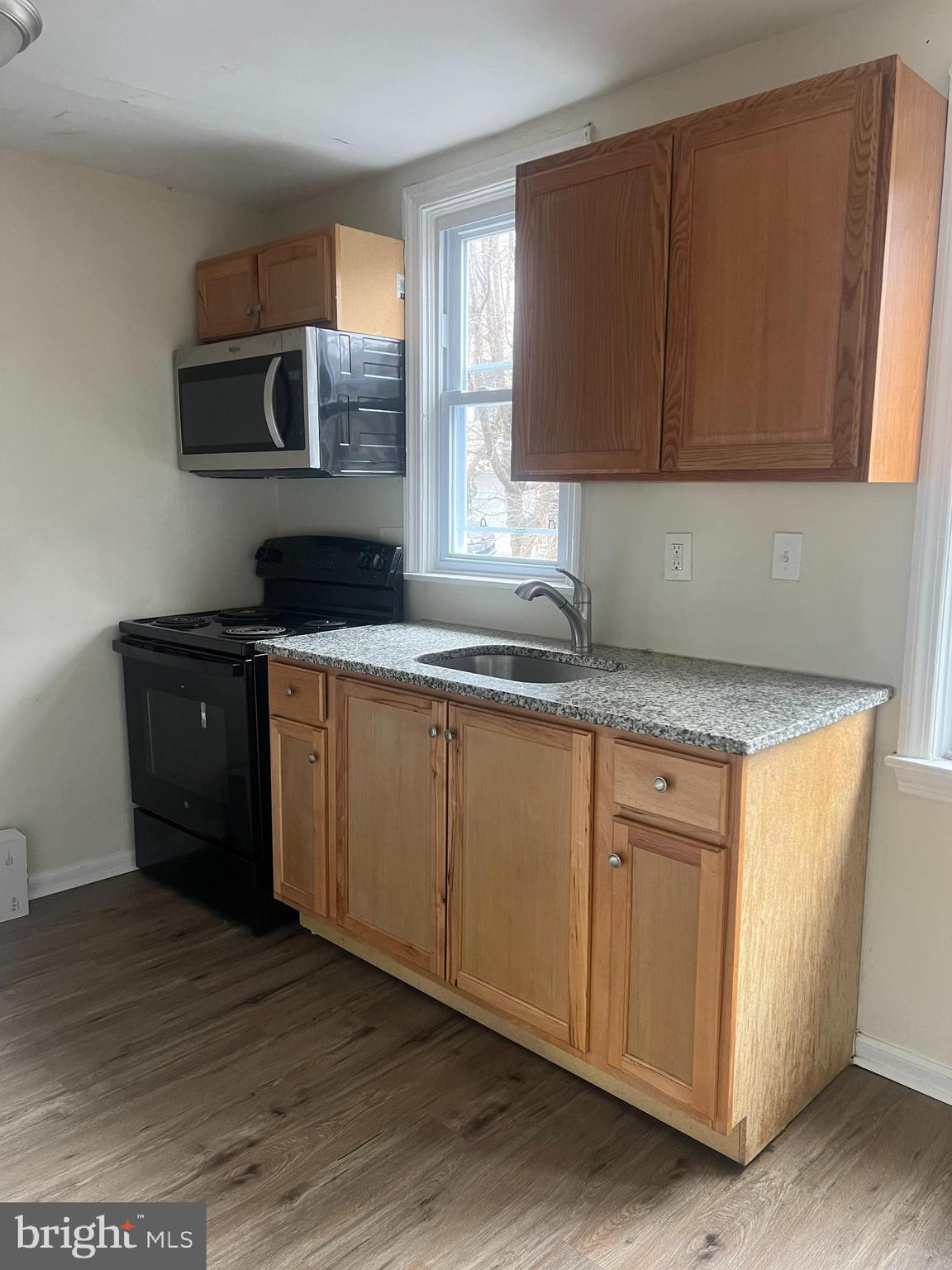 153 Margate Road Upper Darby, PA 19082 - Photo 4 of 7 a kitchen with stainless steel appliances granite countertop a sink a stove a microwave a counter space and cabinets