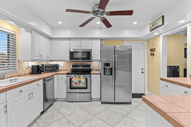 a kitchen with stainless steel appliances a refrigerator sink and microwave