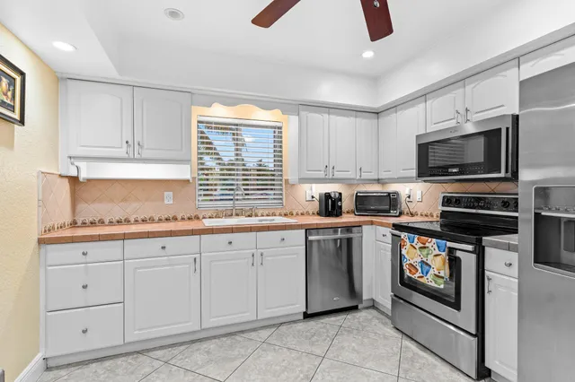 a kitchen with cabinets appliances and a window