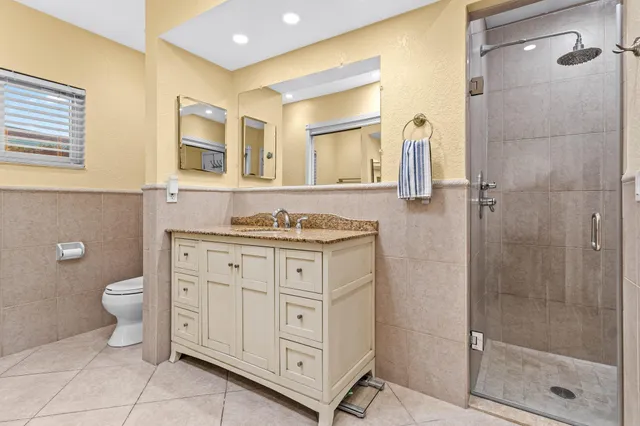a bathroom with a granite countertop toilet sink and shower