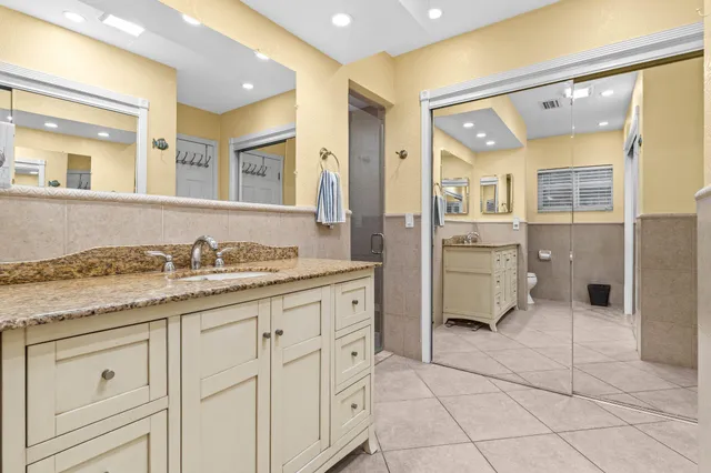 a spacious bathroom with a granite countertop sink mirror and