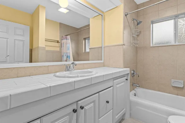 a bathroom with a granite countertop sink a toilet and shower