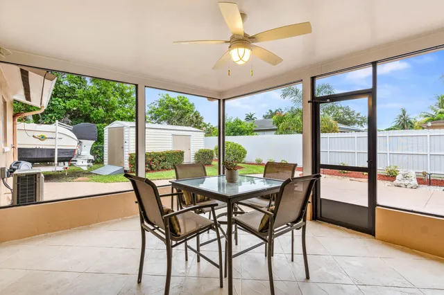 a dining room with furniture and a floor to ceiling window