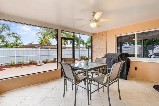 a dining room with furniture and a floor to ceiling window