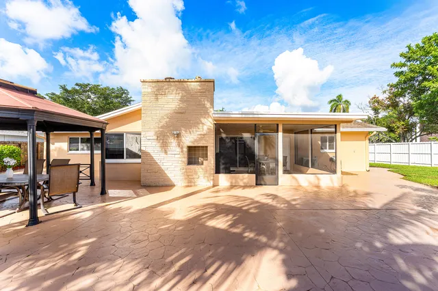 a view of a house with backyard and sitting area