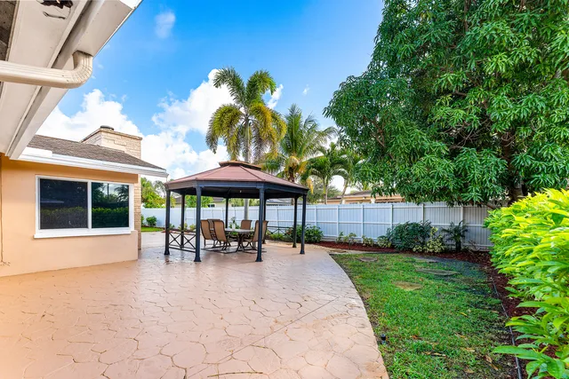 a patio with a table and chairs under an umbrella