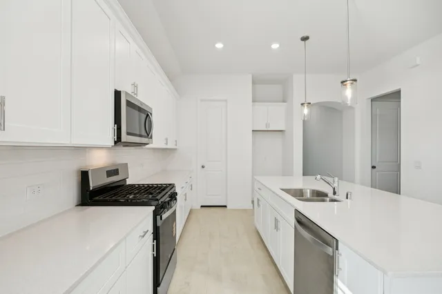 a kitchen with a sink stove and refrigerator