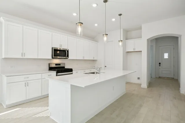 a kitchen with white cabinets and stainless steel appliances