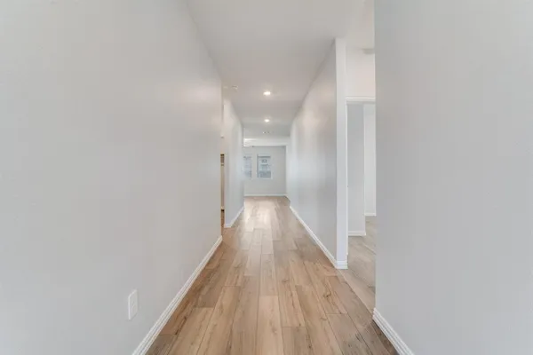 a view of a hallway with wooden floor