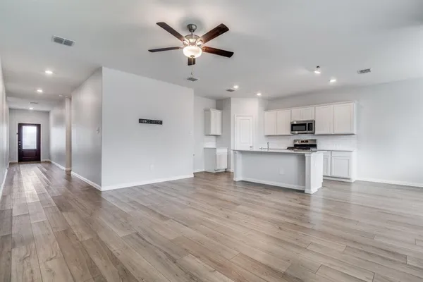 a view of kitchen with cabinets appliances and wooden floor